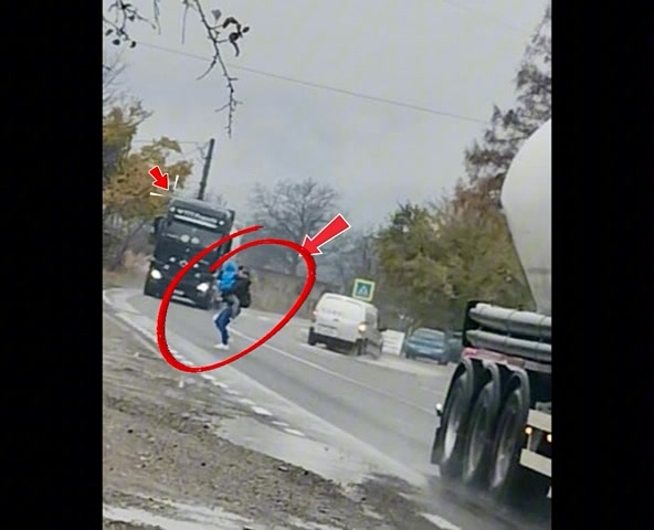 Avertisment despre siguranța pietonilor: exemplul unei mame cu copil trecând printre TIR-uri